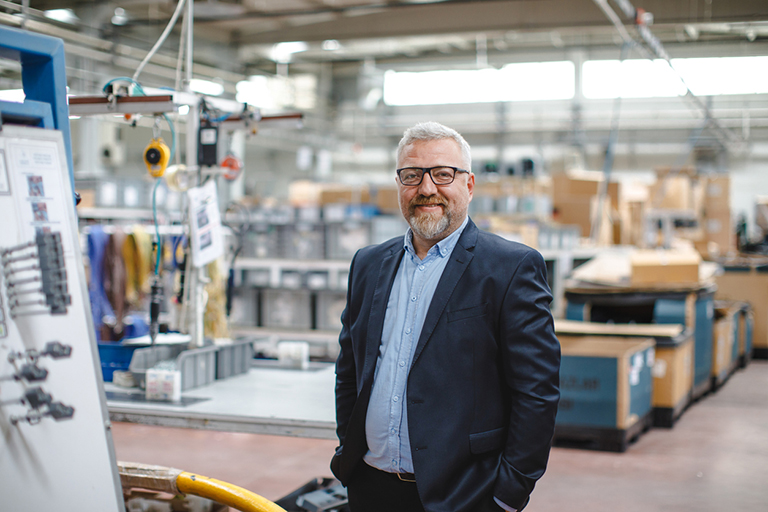 Workforce, Efficient Factory Management: Portrait of Smiling Senior Manager Businessman or CEO in Industrial Factory Warehouse