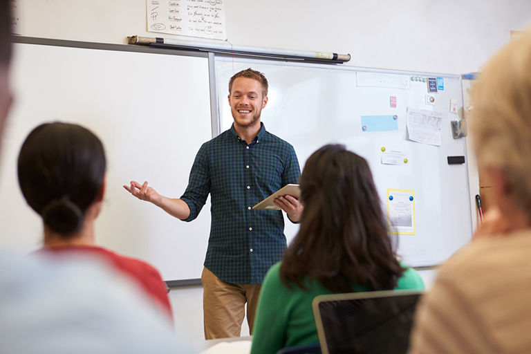 Workforce, Male teacher listening to students at adult education class
