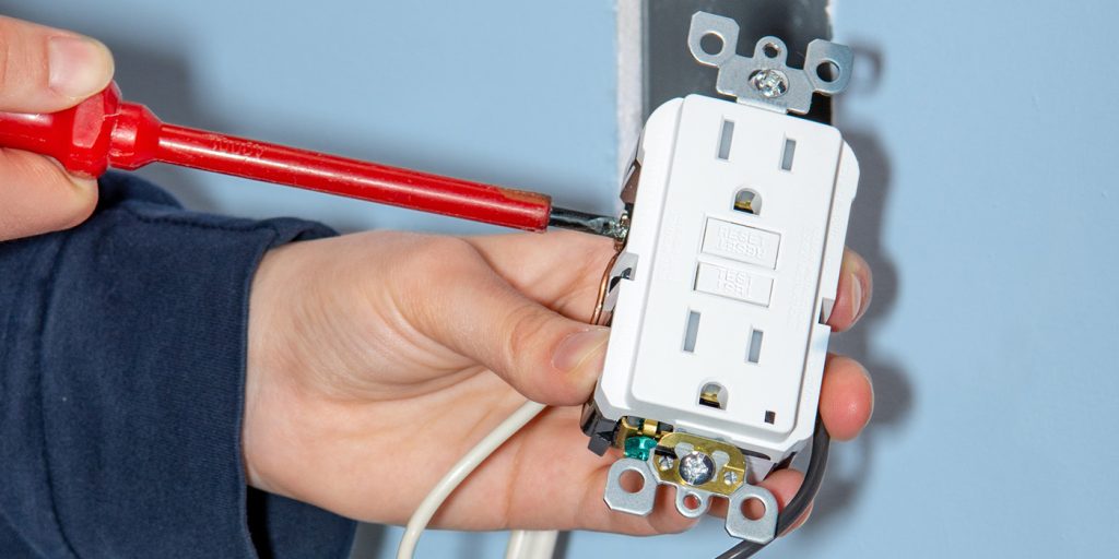 Electrician Training, hands installing outlet