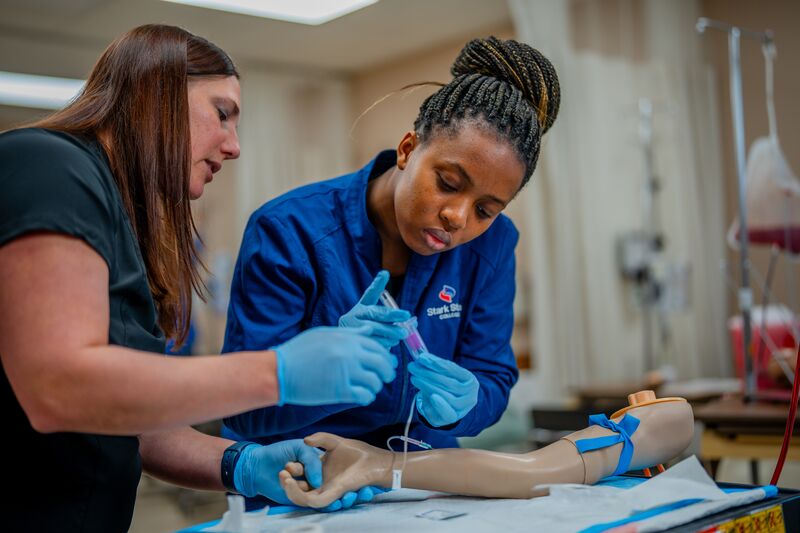 Associate degree in nursing, lab, instructor with student injecting medicine to simulator