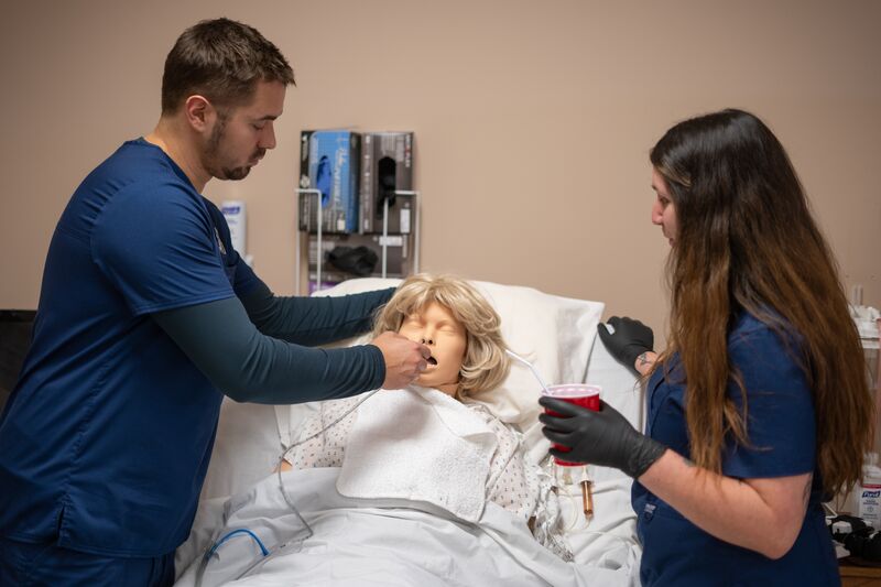 Associate degree in nursing, lab, two students working on simulator