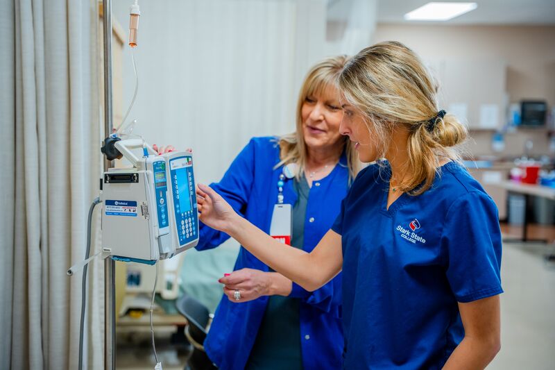Associate degree in nursing, lab, instructor with student on machine