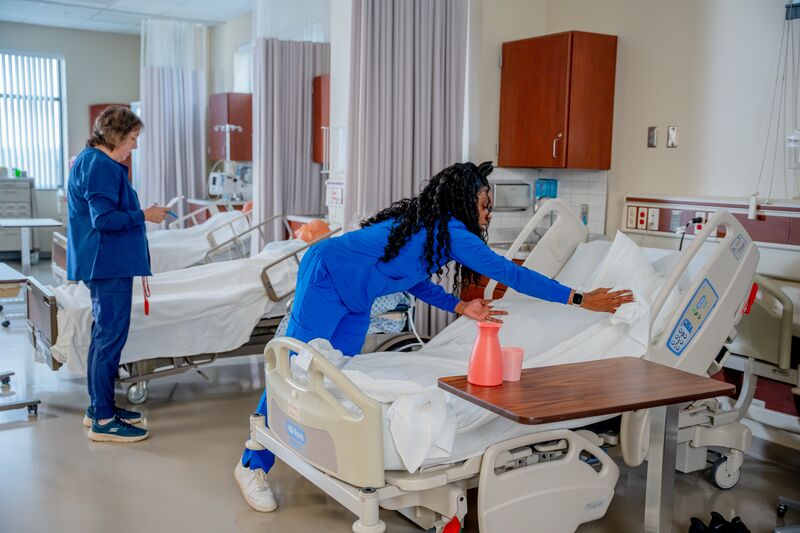 certified nurse aide (CNA), lab, female student, instructor and cleaning bed