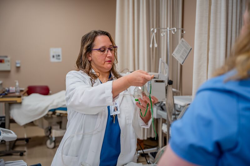 RN completion for LPN, female instructor demonstrating in lab