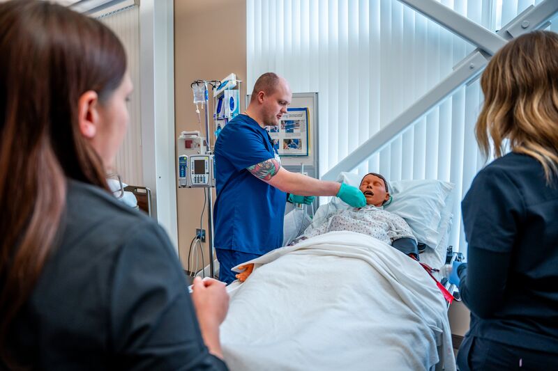 RN completion or paramedic, paramedic to RN lab, students working on simulator as instructor watches