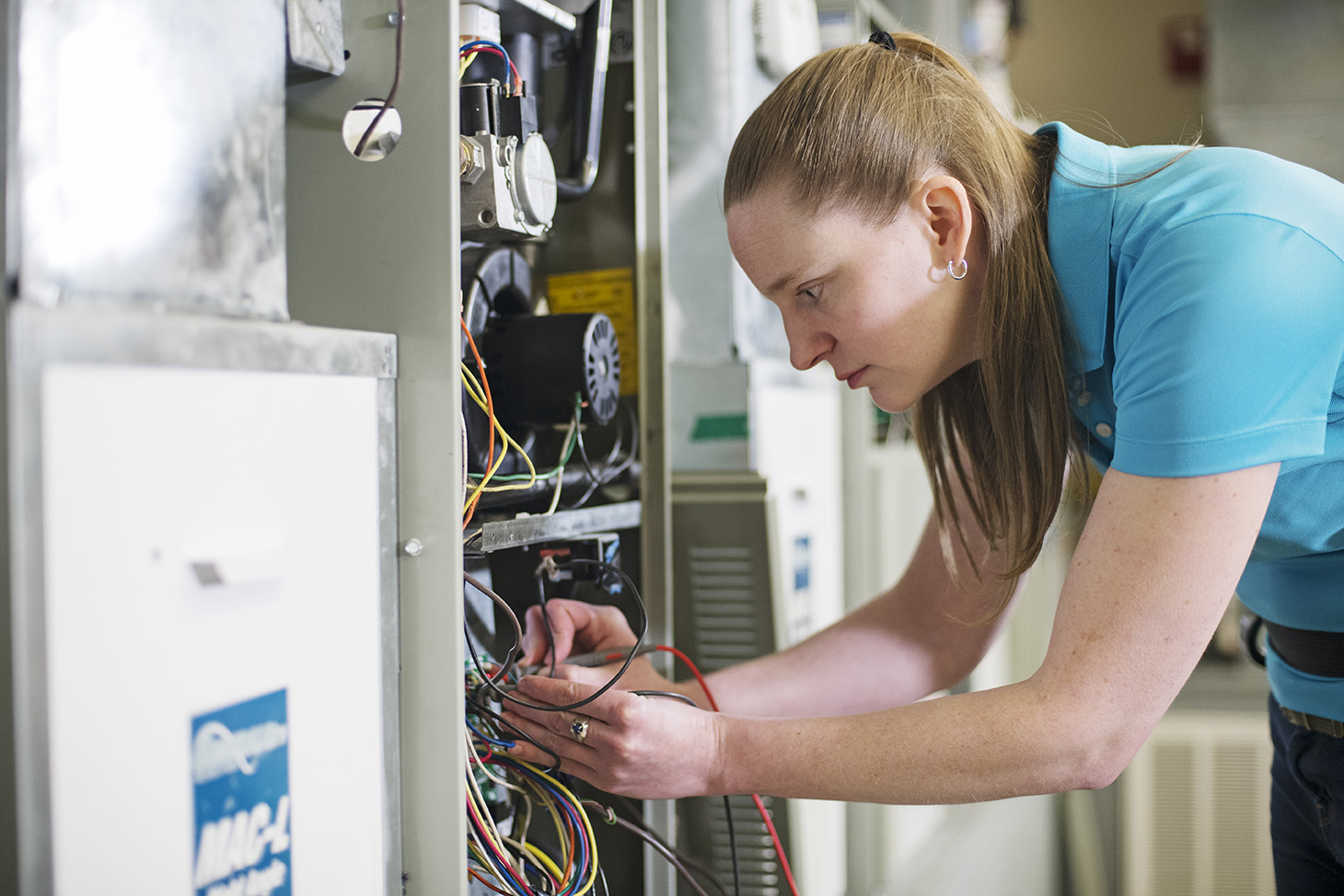 HVAC student, female, working on HVAC electrical system at Stark State