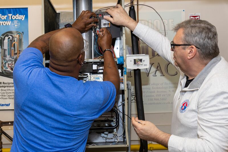 HVACR student and instructor checking circuits of an air conditioner