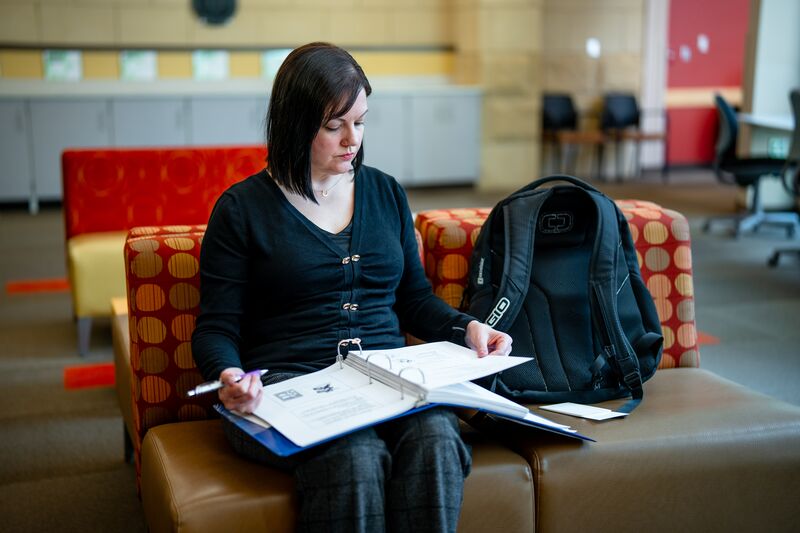 Female student studying with notebook on a bench