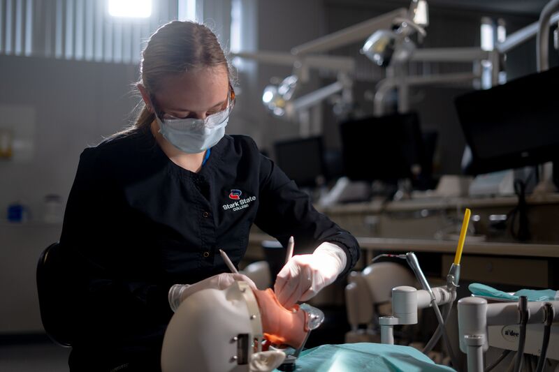Female dental hygiene student working on simulator