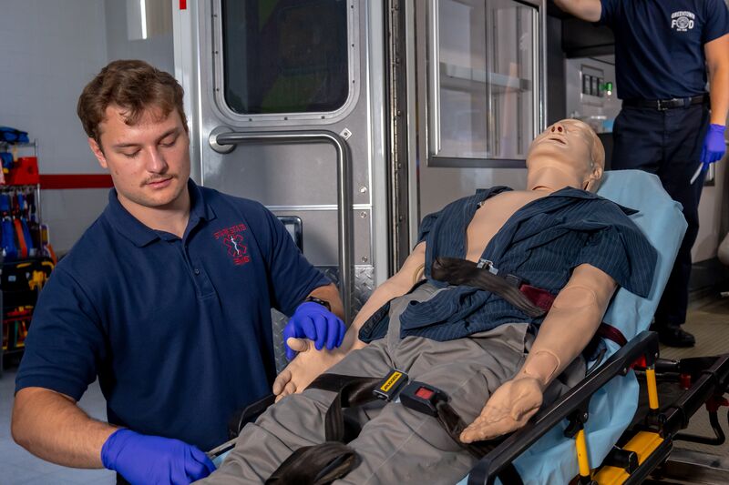 EMS student securing simulator in gurney