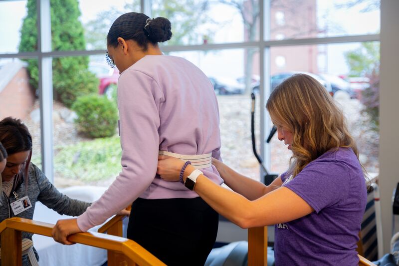 Physical therapy assisting program, two female students helping to walk