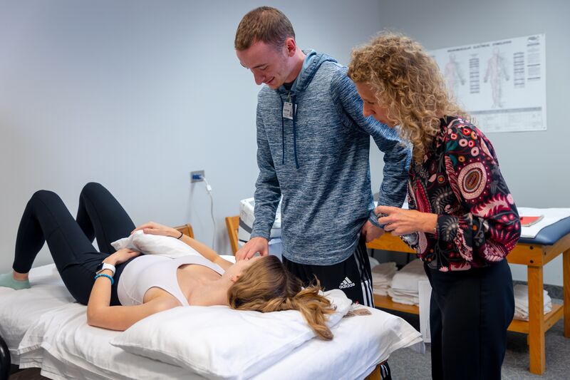 Physical therapy assisting program, instructor helping two students