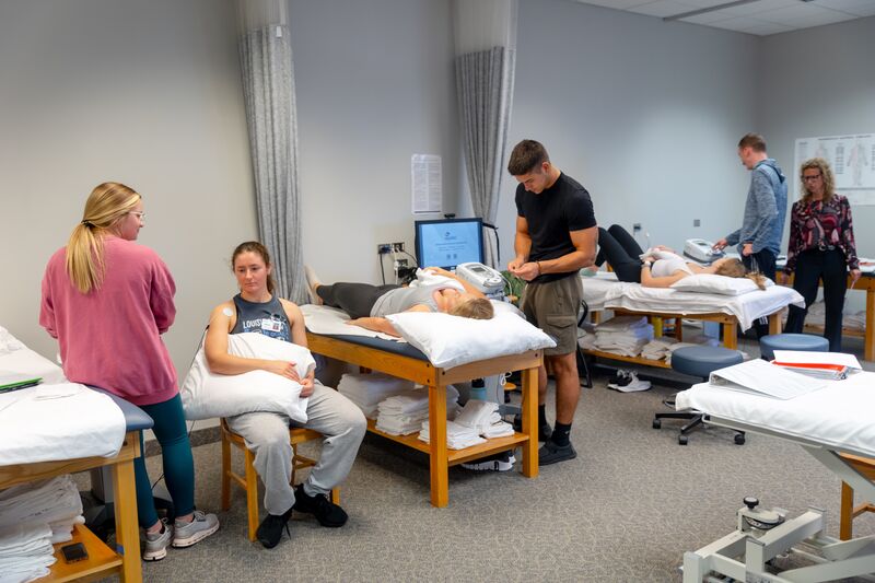 Physical therapy assisting program, class of students working on various techniques
