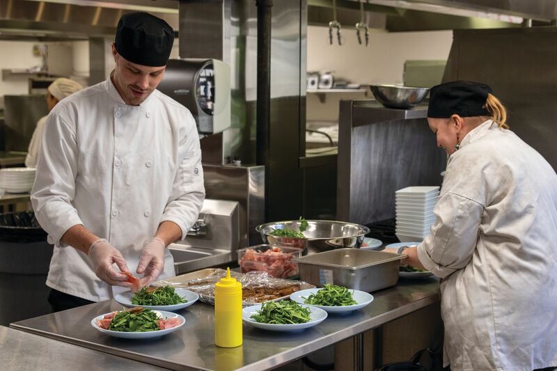 two culinary students preparing a dish