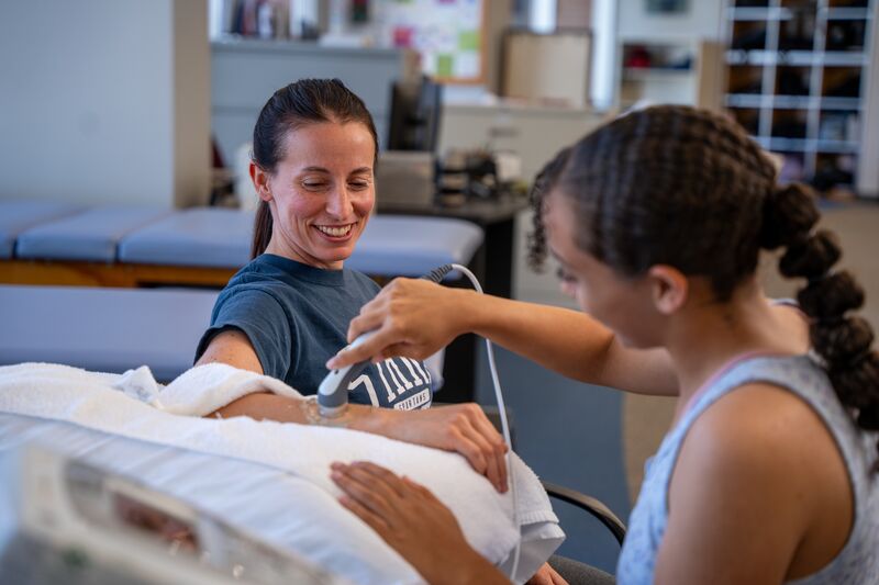 Physical therapy assisting program, two female students using an ultrasound scanner device
