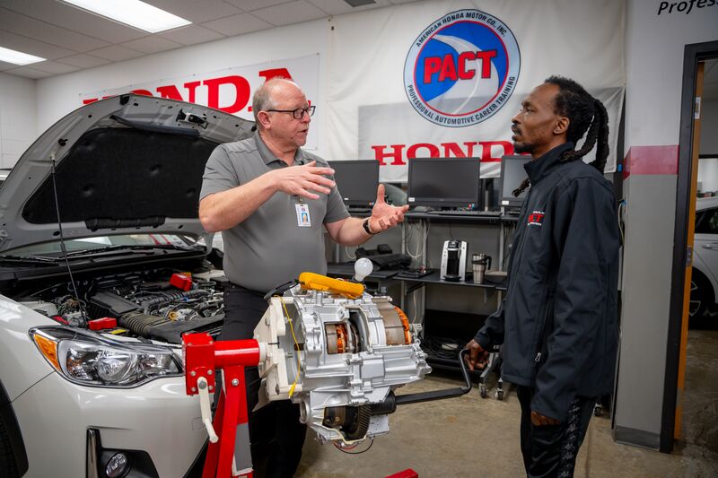 male automotive student receiving instruction from male instructor