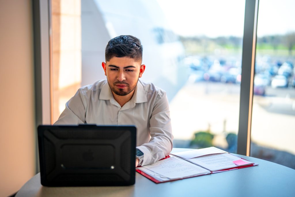 male student sitting at laptop working