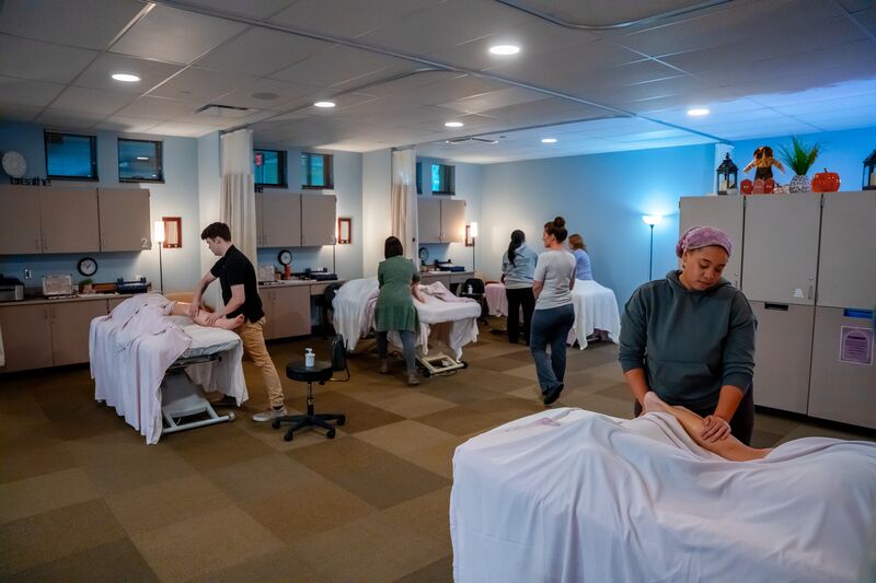 Massage therapy students in clinic practicing techniques on fellow students