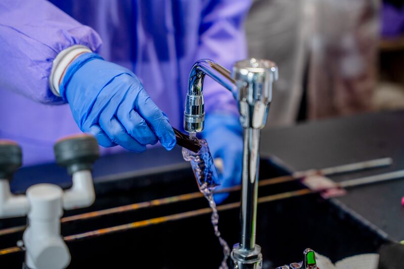 Medical laboratory, hands at sink washing medical instrument