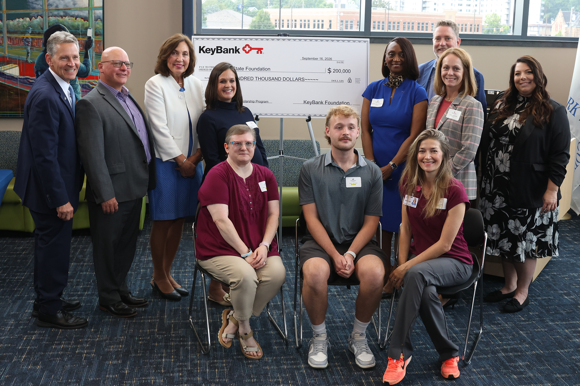 KeyBank check donation to Stark State College as members of Stark State College including three students and representatives from KeyBank pose picture in front of large check.